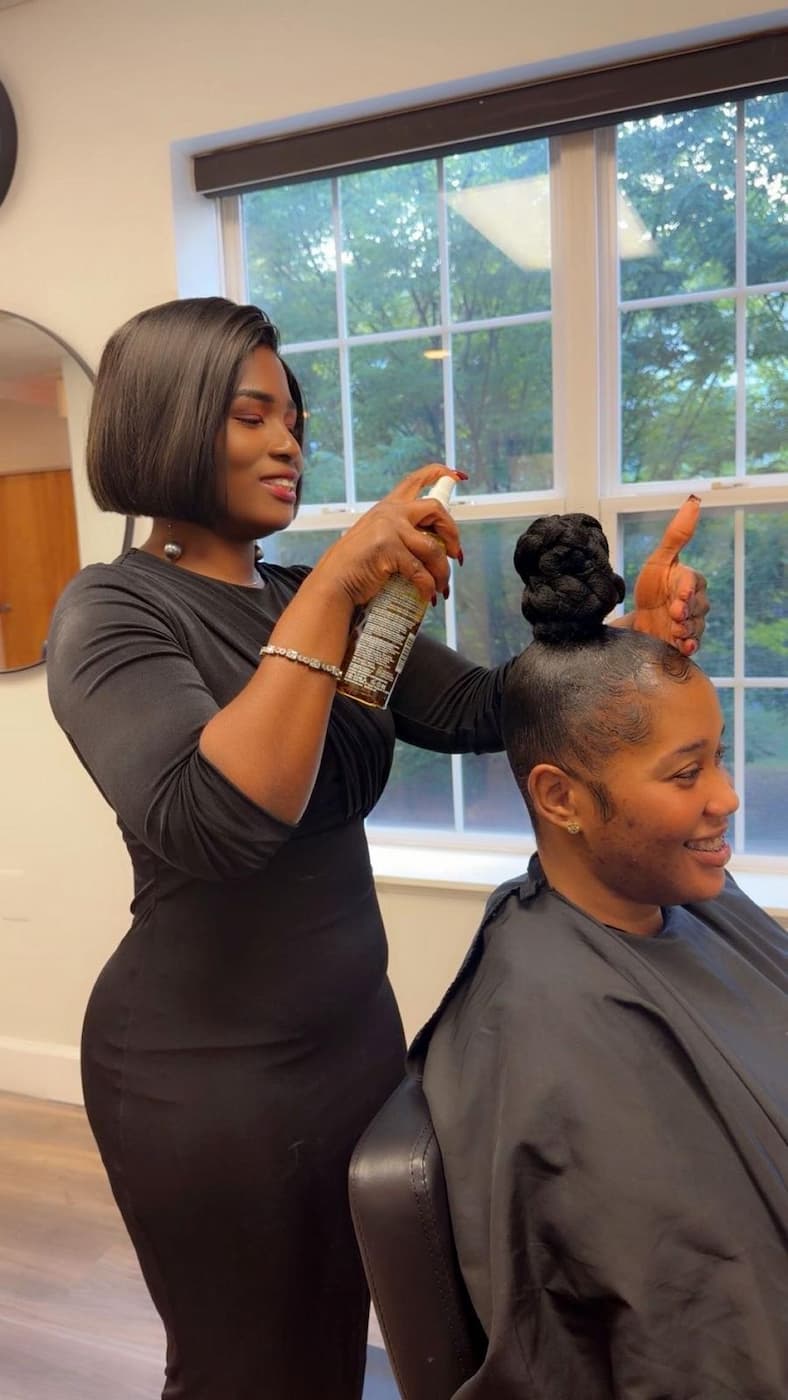House of Glamor stylist finishing a client hairstyle